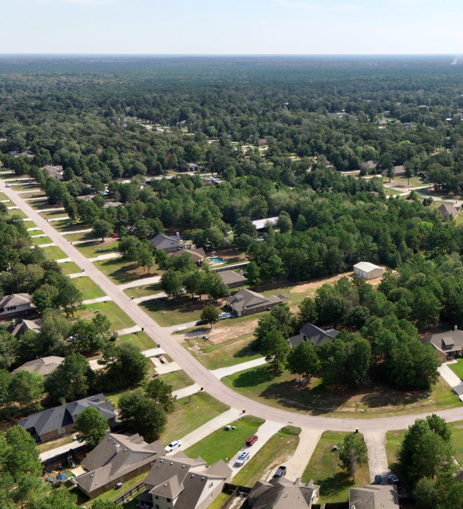 Aerial view of a curving Deer Trail II street with homes and tall trees